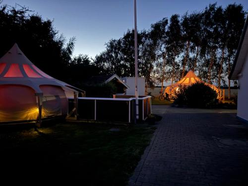 a couple of tents in a yard at night at Romantik Luxus Glamping 4 in Idestrup