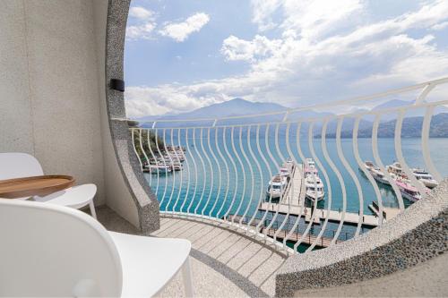 a balcony with a view of a marina with boats at Sun Moon Lake Apollo Resort Hotel in Yuchi