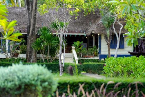 a house with a garden with trees and bushes at Baan Thong Ching Resort in Khanom