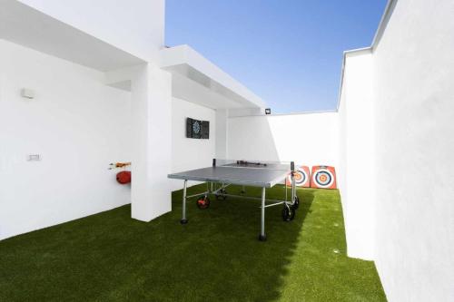 a ping pong table in a white room with green grass at Vivienda vacacional de lujo en el sauzal in Sauzal