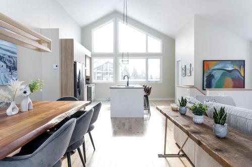 a kitchen and living room with a long wooden table at Ski Mont Saint-Anne - Absolute Comfort - Mont Lumina in Beaupré