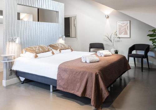 a bedroom with a large bed and two chairs at Stylish Suite Near Gouden Ham Wifi Ac in Oss
