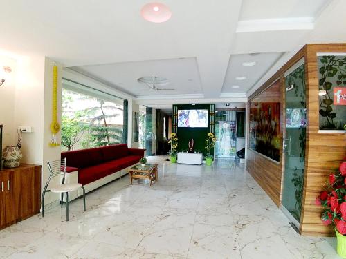 a living room with a red couch and a table at Hotel Sai SK Palace in Shirdi