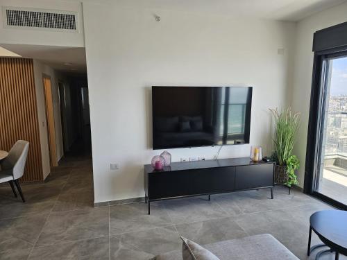 a living room with a large flat screen tv on a wall at High sea luxury apartment in Bat Yam