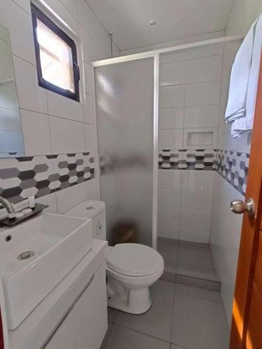 a white bathroom with a toilet and a shower at Casa Benito Resort in Sauay