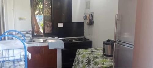 a kitchen with a stove and a sink and a refrigerator at Casa Benito Resort 