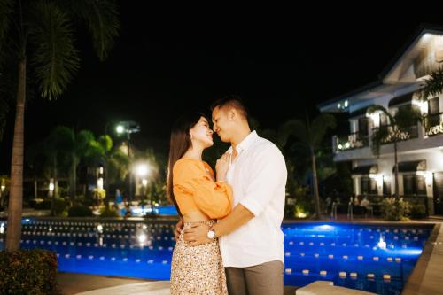 a couple kissing in front of a pool at night at Ilocos Urban Wave Resort in Laoag