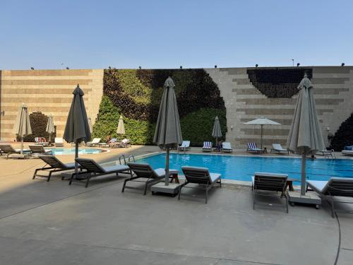 a swimming pool with chairs and umbrellas next to a pool at شقه فندقيه نيل هلتون ريزيدنس المعادي in Cairo