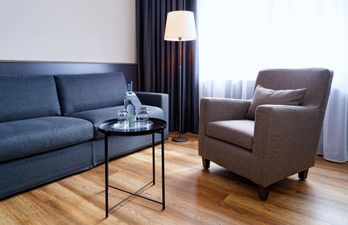 a living room with a couch and a chair at ATLANTIC Hotel Landgut Horn in Bremen