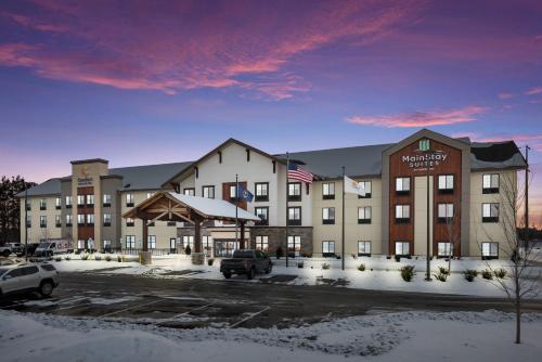 a large hotel in a parking lot with snow at MainStay Suites Gaylord in Gaylord