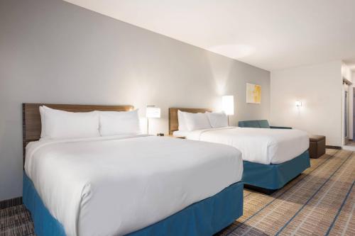 a hotel room with two beds and a couch at MainStay Suites Gaylord in Gaylord