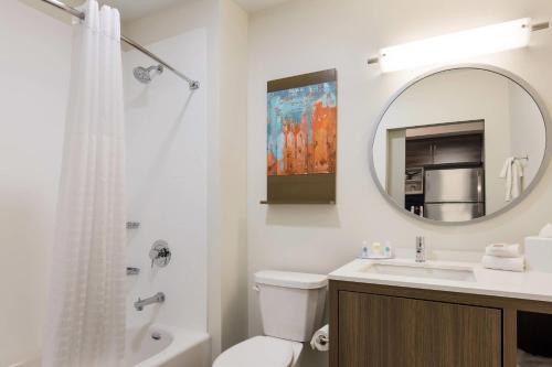 a bathroom with a sink and a toilet and a mirror at MainStay Suites Gaylord in Gaylord