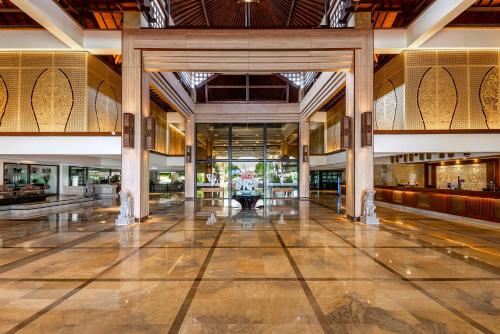 an empty lobby of a building with columns at Discovery Kartika Plaza Hotel in Kuta
