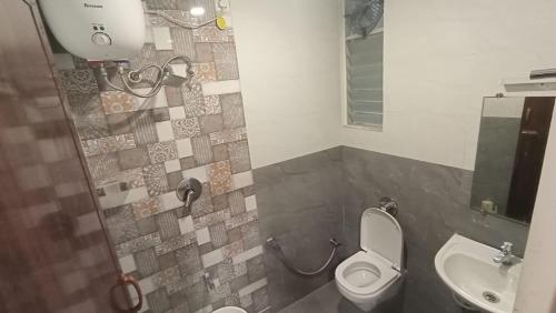a bathroom with a toilet and a sink at Ganga Residency Tiruvannamalai in Tiruvannāmalai