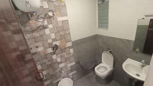 a bathroom with a toilet and a sink at Ganga Residency Tiruvannamalai in Tiruvannāmalai