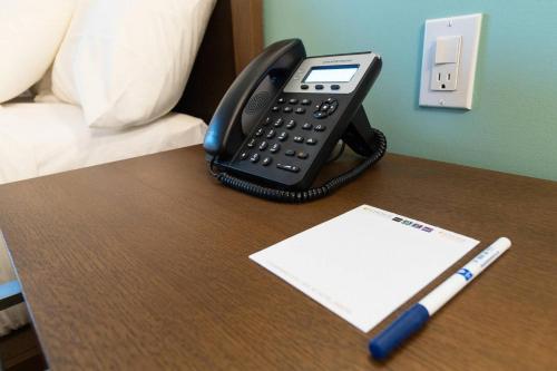 a desk with a phone and a pen on it at Comfort Inn Ciudad Juarez in Ciudad Juárez