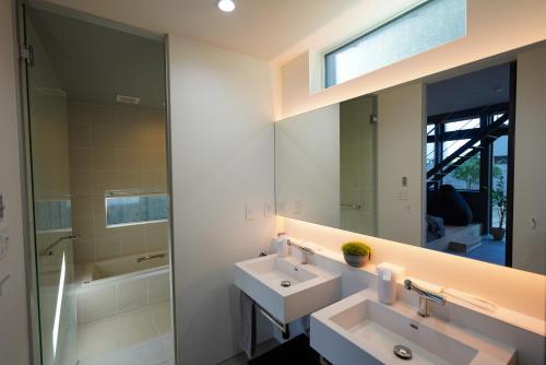 a bathroom with two sinks and a mirror at amairo Villa in Asahikawa