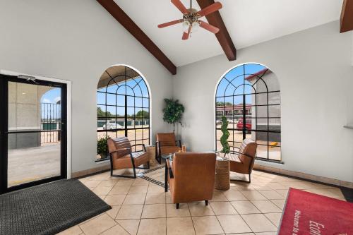 a living room with a ceiling fan and windows at Econo Lodge in Belton
