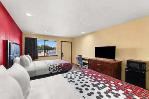 a hotel room with two beds and a flat screen tv at Econo Lodge in Belton