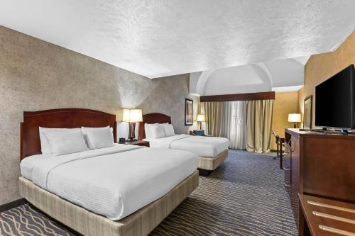 a hotel room with two beds and a flat screen tv at Radisson Hotel Salt Lake City Airport in Salt Lake City
