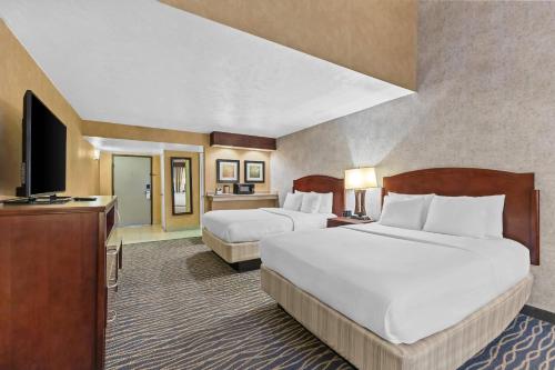 a hotel room with two beds and a flat screen tv at Radisson Hotel Salt Lake City Airport in Salt Lake City