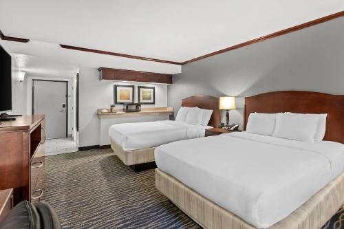 a hotel room with two beds and a television at Radisson Hotel Salt Lake City Airport in Salt Lake City