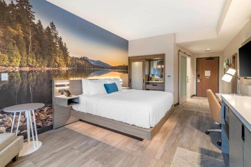 a bedroom with a bed and a view of a lake at Cambria Hotel Lake Placid - Lakeside Resort in Lake Placid