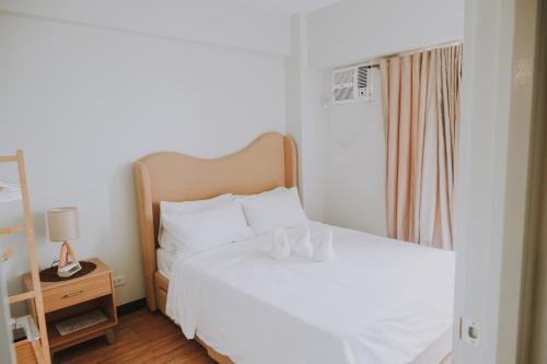 a bedroom with a white bed and a mirror at Casa Palma at Verdon Parc in Davao City