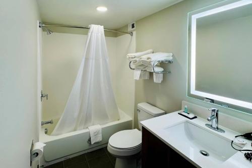 Un baño con inodoro, lavabo y ducha. en MainStay Suites Chambersburg, en Chambersburg