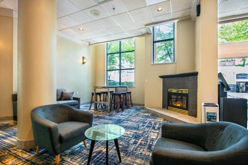 a living room with two chairs and a fireplace at Grand Park Hotel & Suites Downtown Vancouver, an Ascend Collection Hotel in Vancouver