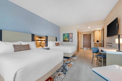 a hotel room with two beds and a desk at Cambria Hotel Austin Downtown in Austin