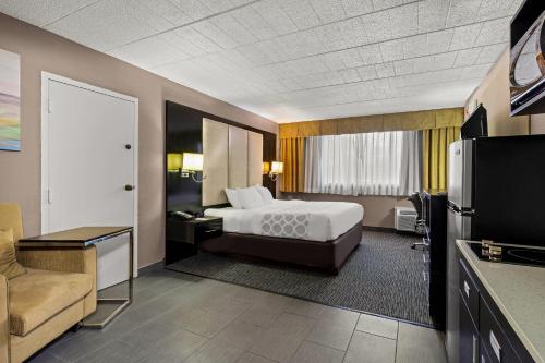 a hotel room with a bed and a television at Suburban Studios in Altoona