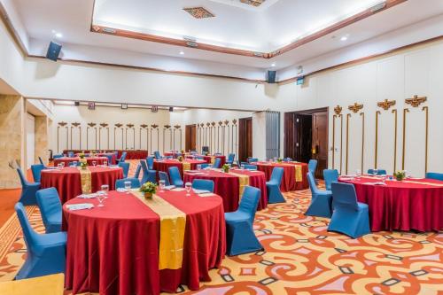 a banquet hall with red and blue tables and chairs at Discovery Kartika Plaza Hotel in Kuta