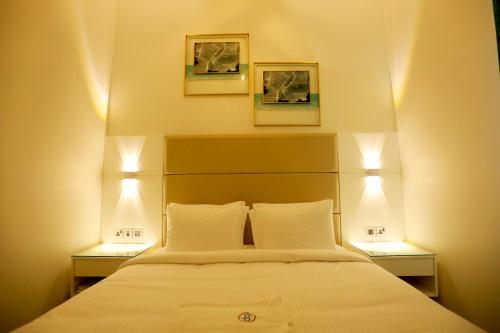 Un dormitorio con una cama con dos lámparas encima. en DREAM PALACE HOTEl, en Ras al Khaimah