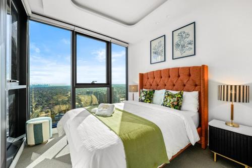 a bedroom with a bed and large windows at Highrise Luxury Penthouse Spectacular Views in Box Hill