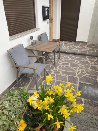 a patio with two chairs and a table and flowers at Wiesenblick Mils in Mils bei Hall