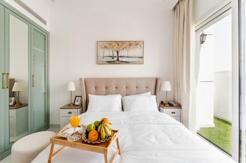 a bedroom with a bed with a tray of fruit on it at 1BR Lagoon View Luxury Spa Retreat near Miracle Garden By Green Sky Holiday Homes in Dubai