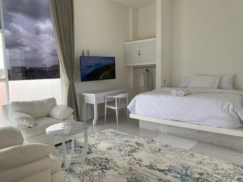 a white bedroom with a bed and a couch at Klissy Studio Villa in Kerobokan