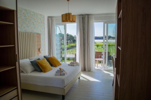 a bedroom with a bed and a large window at Esperidi Paestum Agri Resort in Capaccio-Paestum