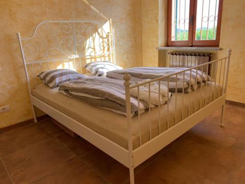 a white bed with pillows on it in a room at Villa Corleone in Nizza Monferrato