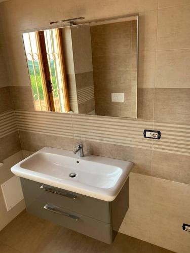 a bathroom with a white sink and a mirror at Villa Corleone in Nizza Monferrato