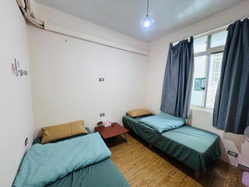 a room with two beds and a window at MatchBox Hostel in Longjing