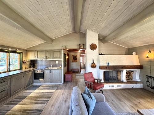 a large kitchen with a couch and a table at Briskebu, cosy cabin by ski slopes in Geilo