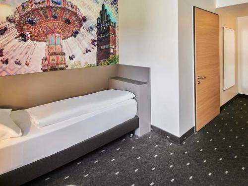 a bed in a room with a painting on the wall at B&B Hotel Darmstadt in Darmstadt