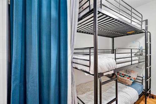 ガイヤックにあるAppartement proche merのベッドルーム1室(青いカーテン付きの二段ベッド2組付)