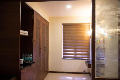 a bathroom with a shower and a window with a shutter at Hotel High Point in Tiruchchirāppalli