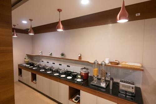 a kitchen with a counter with a stove top oven at Hotel High Point in Tiruchchirāppalli
