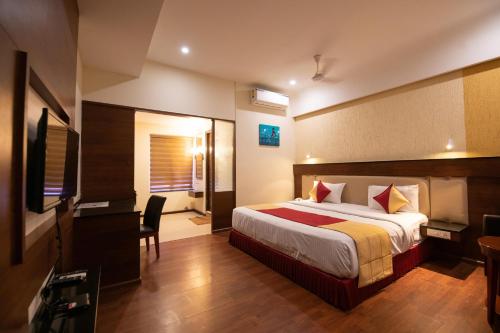 a hotel room with a bed and a desk at Hotel High Point in Tiruchchirāppalli