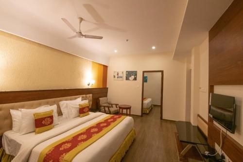 a hotel room with a bed and a flat screen tv at Hotel High Point in Tiruchchirāppalli