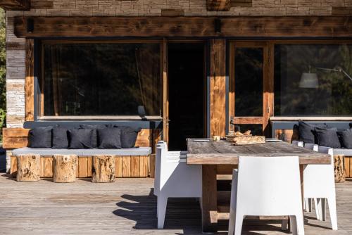 a wooden table and chairs on a porch with a couch at Chalet D'albiez in Albiez-Montrond